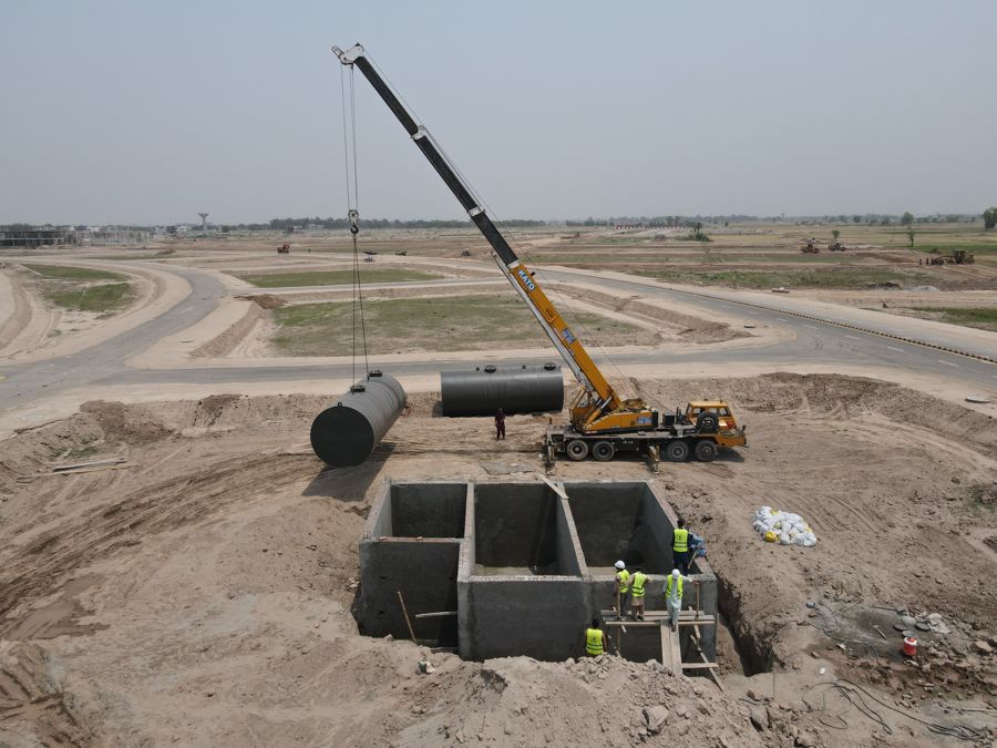 Crane installing underground tanks on site